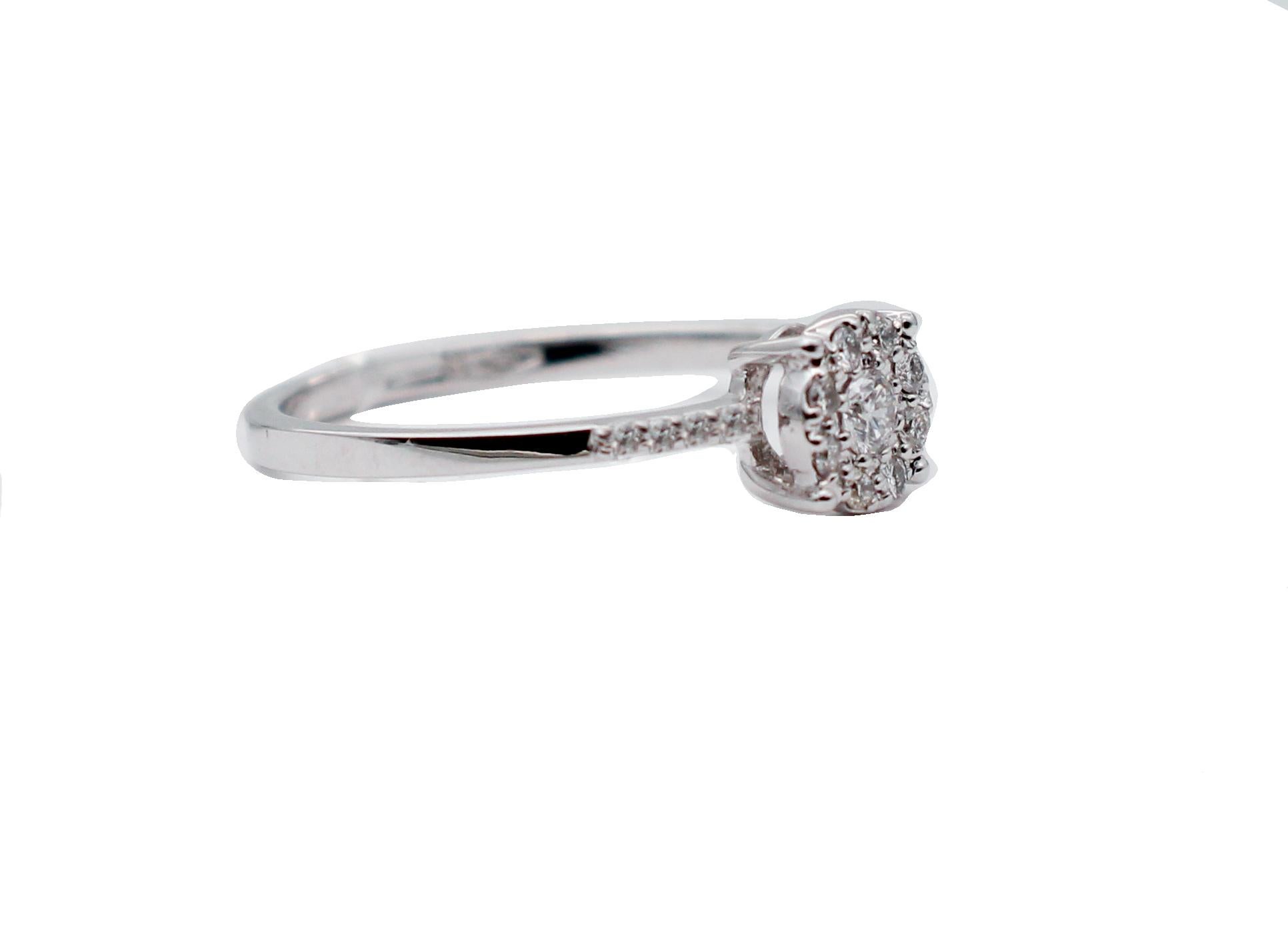 Beautiful ring in 18 karat white gold structure studded with a bigger diamond in the central part surrounded by little diamonds. 
Diamonds 0.21 ct
Total Weight 1.95 gr
RF  +RER
Italian Size 17
French Size 57
Usa Size 8

For any inquires,please