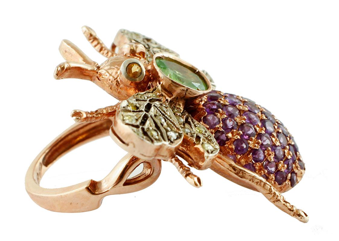 Particular fashion ring in 9 kt rose gold and silver structure with the shape of a fly. It has two yellow topaz as eyes and one tsavorite on the neck. The body is studded with amethyst and its wings with little diamonds.
This ring is totally