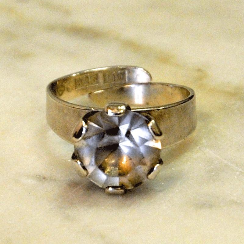 A beautiful sterling silverring with a neat, clear and diamond shaped stone surrounded by a crown of silver that holds on to it and makes it look like a beautiful flower. Modernism. The ring is adjustable and marked with HSG D 925 C10.
Measures: