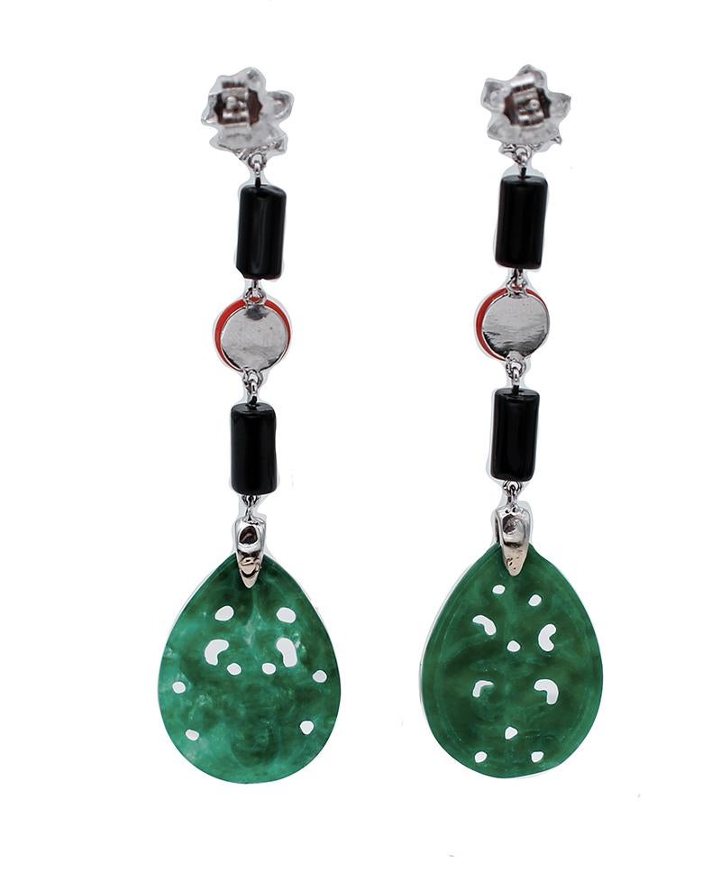 Gorgeous dangle earrings mounted with a 18 karata white gold flower in the upper part studded with a little coral surrounded by diamonds. In the middle part, two onyx and,between of them, a coral bottom and a green agate as pendant.
These earrings