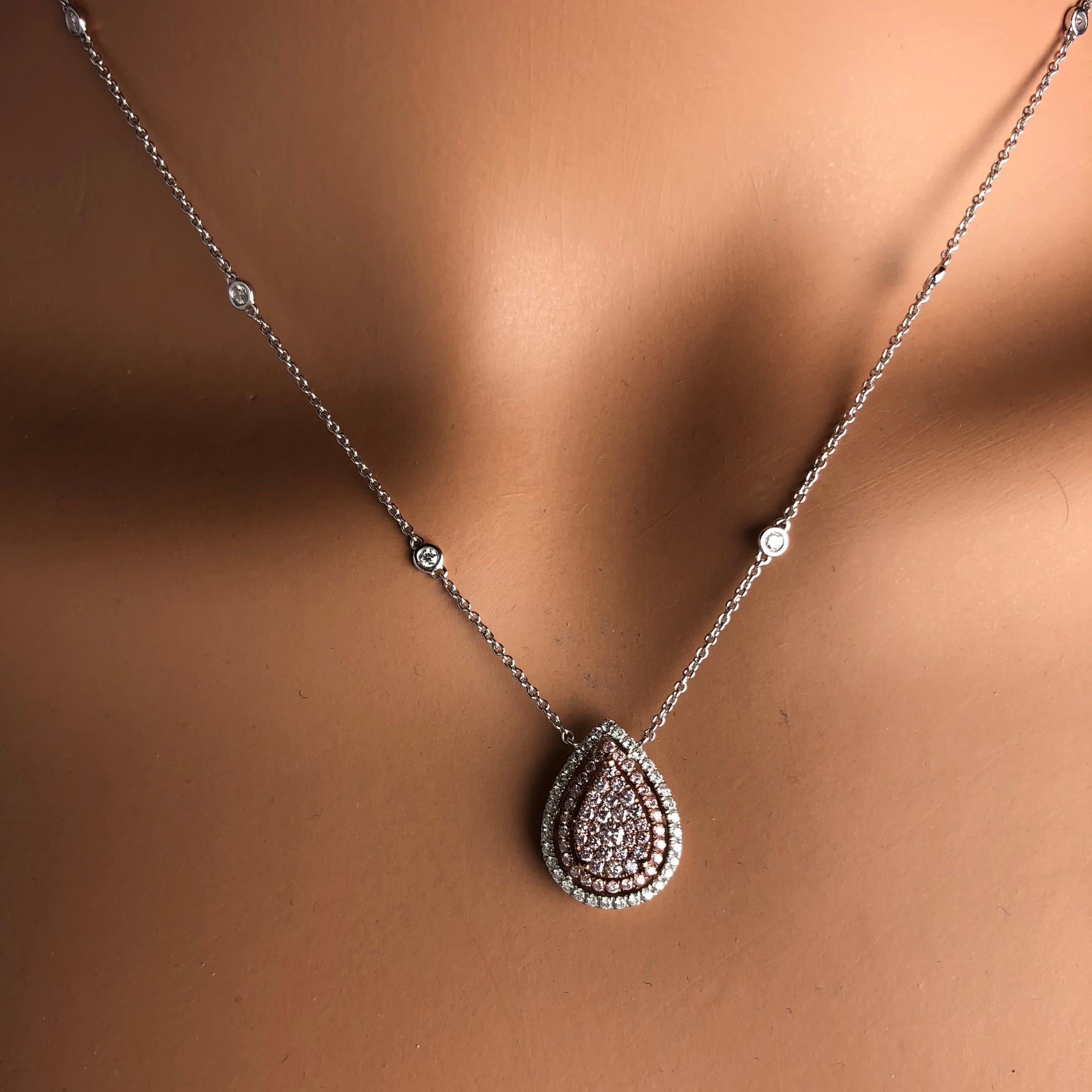 (DiamondTown) This gorgeous pendant features round pink diamonds carefully arranged to give the impression of a pear shaped center. This is surrounded by a double halo of round pink and round white diamonds, as well as diamonds placed along the