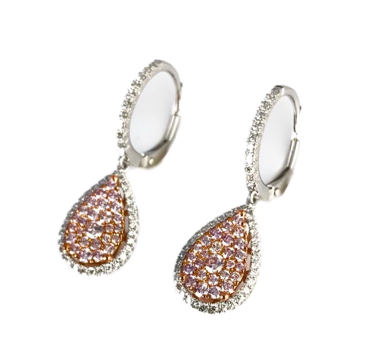 Diese wunderschönen Ohrringe mit Hebelverschluss zeichnen sich durch mehrere runde rosa Diamanten aus, die in einer Birnenform angeordnet sind und sich in einem Halo aus runden weißen Diamanten befinden. Weitere Diamanten zieren die Vorderseite des