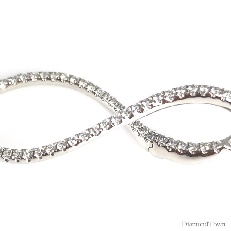 (DiamondTown) You'll love these delicate hoop earrings, with a twist! These earrings take the classic hoop style, and add in a bit of flair in the form of a slight twist to the shape.

Total diamond weight 0.98 carats.
Set in 14k White Gold.

Many