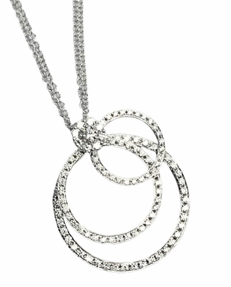 This beautiful pendant has three layered circle frames set with round diamonds, dangling from a round base bail. Each frame of diamonds has free side-to-side motion for a playful dangle on the neck. The total diamond weight is 1.19 carats.

The