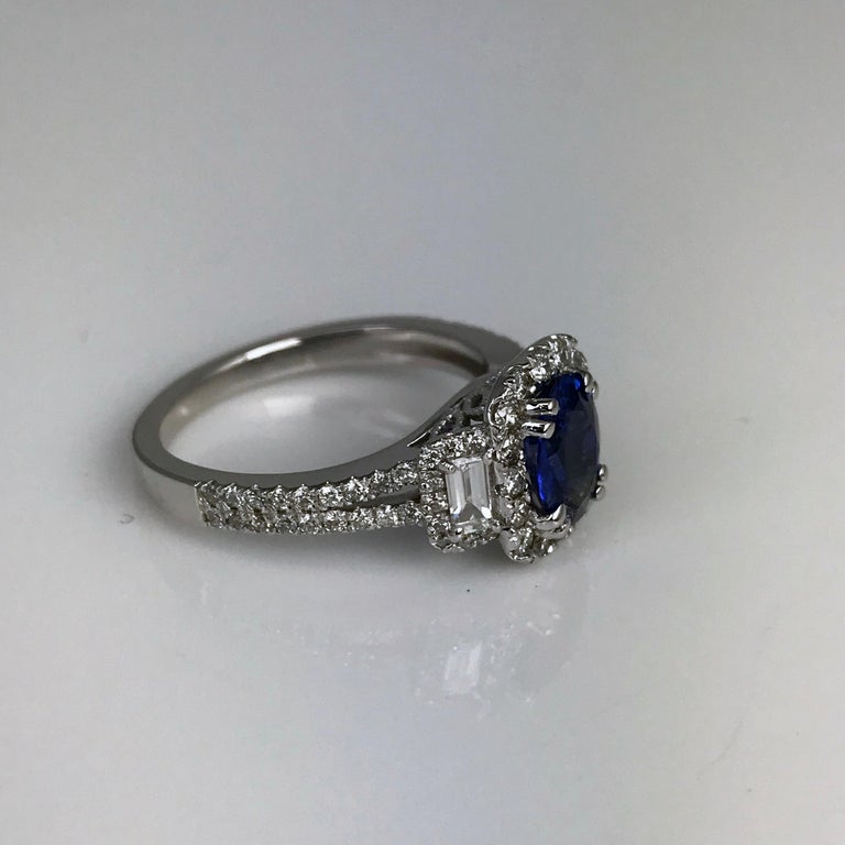 This ring has a 1.22 carat oval cut sapphire center, within a round diamond halo and flanked by two baguette diamonds. Additional diamonds trail down the split shank. Total diamond weight 0.83 carats.

Sapphire: 1.22 carat oval cut
Diamonds: 0.83