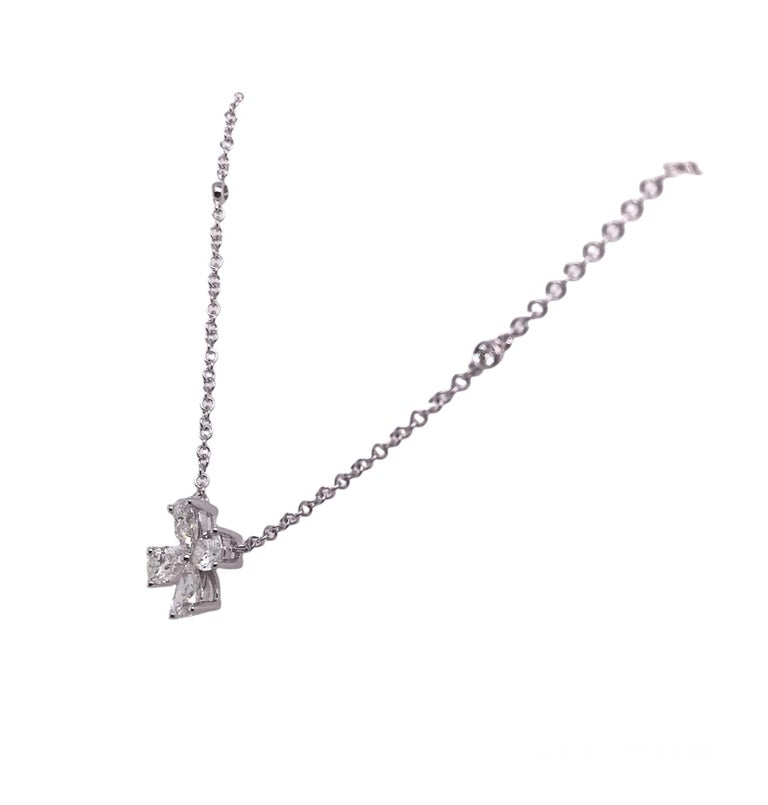 This simple necklace's elegance comes from four delicately placed pear shape diamonds forming a pinwheel shape. Additional bezel set diamonds decorate the attached chain.

Total diamond weight 1.38 carats
Set in 18k white gold
18