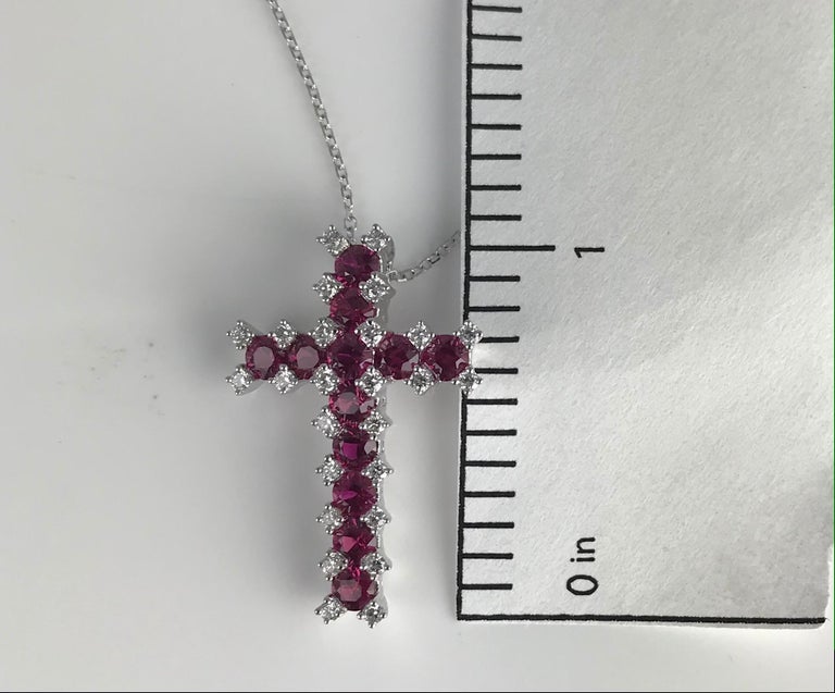 This cross pendant has 12 round rubies and 26 round diamonds. The total ruby weight is 1.52 carats. The total diamond weight is 0.3 carats.

Set in 18k White Gold. Chain length 18