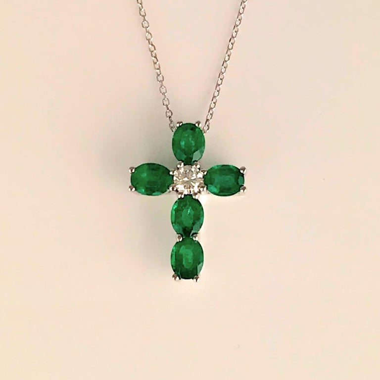 This stunning cross pendant features five oval cut emeralds (total weight 1.49 carats), around a central round diamond. The total diamond weight is 0.19 carats.

Set in 18k White Gold. Chain length 18