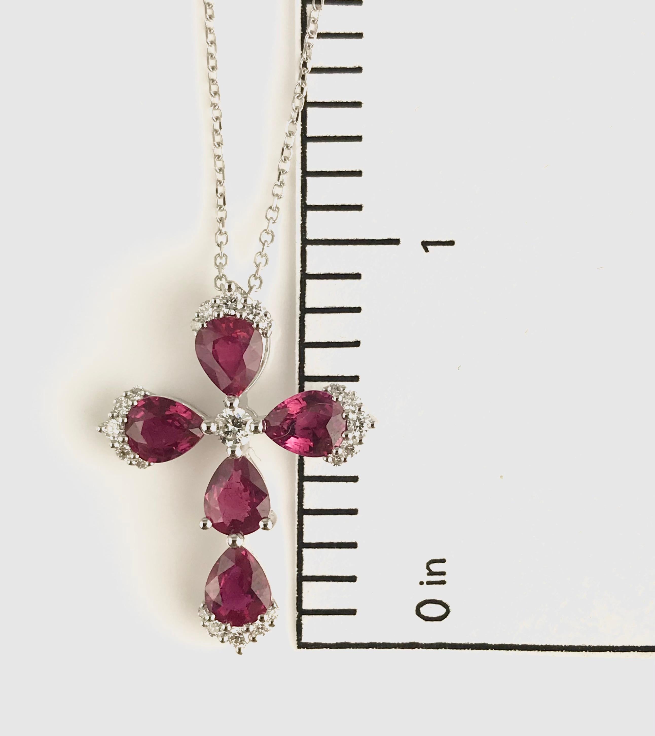 This stunning cross pendant features five pear shaped rubies (total weight 1.81 carats), around a central round diamond and additional clusters of round diamonds at the points of the cross. The total diamond weight is 0.19 carats.

Set in 18k White