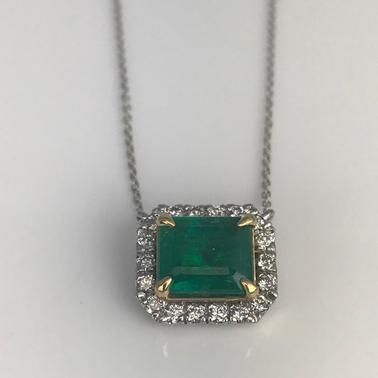This gorgeous pendant has a 2.33 carat emerald cut emerald center, with 0.32 carats round diamond halo. The center emerald is set in an 18k yellow gold accent. The main setting is 18k white gold. The 18