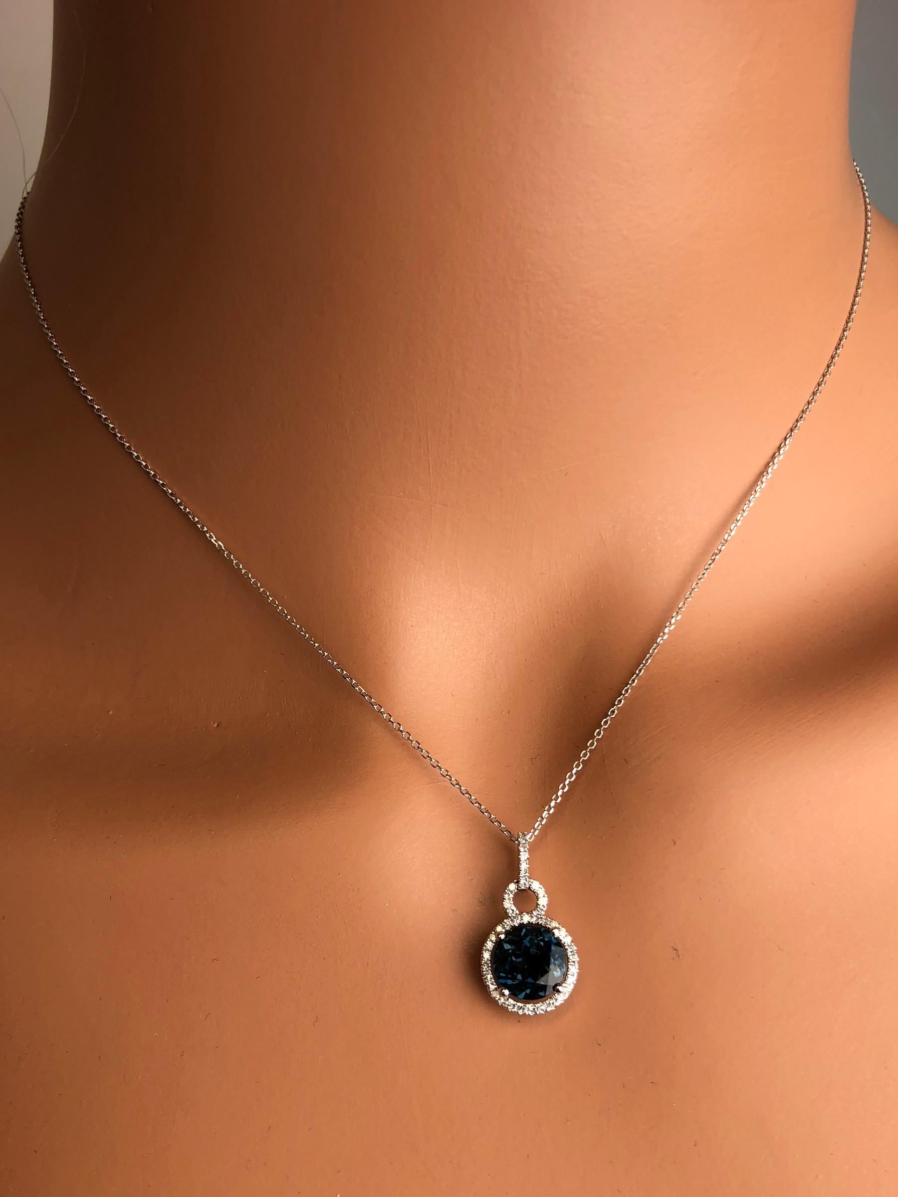 This lovely halo pendant features 2.39 carats round cut London Blue Topaz, surrounded by a halo of round white diamonds. Additional diamonds decorate the bail.

Center: 2.39 carat round cut London Blue Topaz
Diamond Halo: 43 round diamonds total