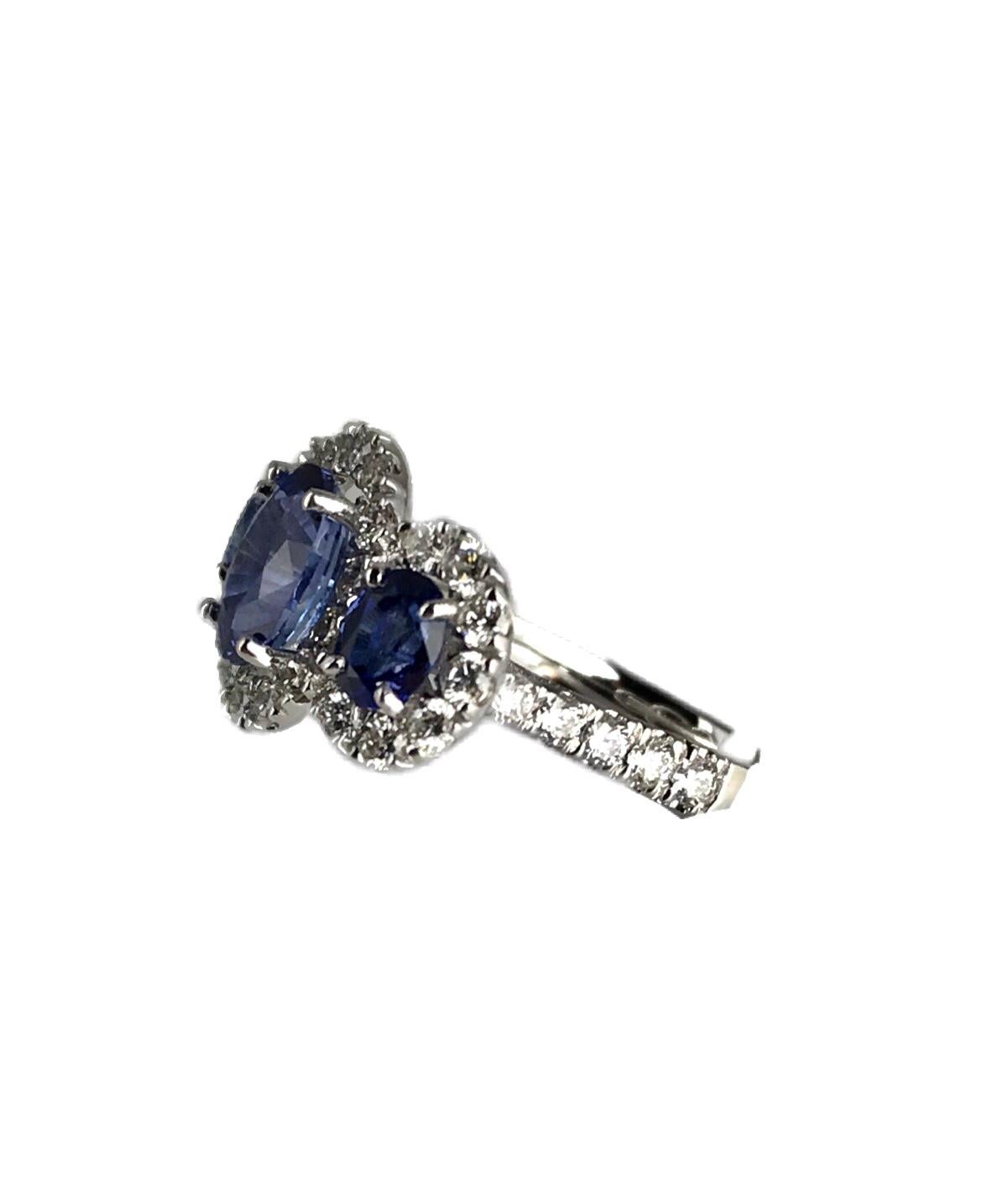 This classic ring features three oval cut sapphires totaling 2.45 carats, each inside a halo of round white diamonds.

Total sapphire weight 2.45 carats.
Total diamond weight 0.91 carats.
Set in 18k White Gold

This ring can be professionally