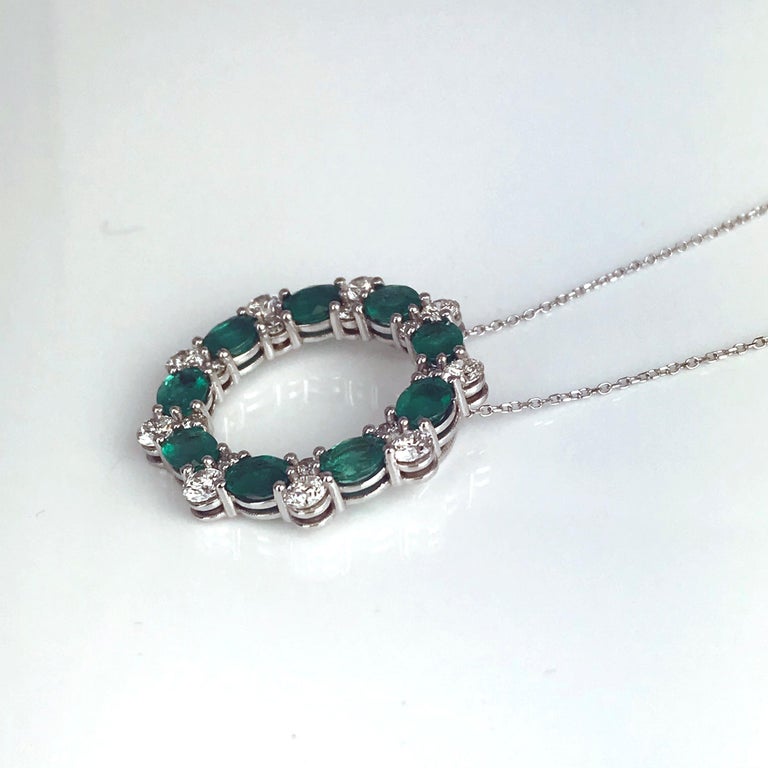 This beautiful circle pendant has nine oval cut emeralds (total weight 2.75 carats) each measuring 5x4mm, among pairs of round white diamonds (total weight 1.38 carats). Set in 18k White Gold.

Emeralds: 9 stones at 5x4mm, total weight 2.75