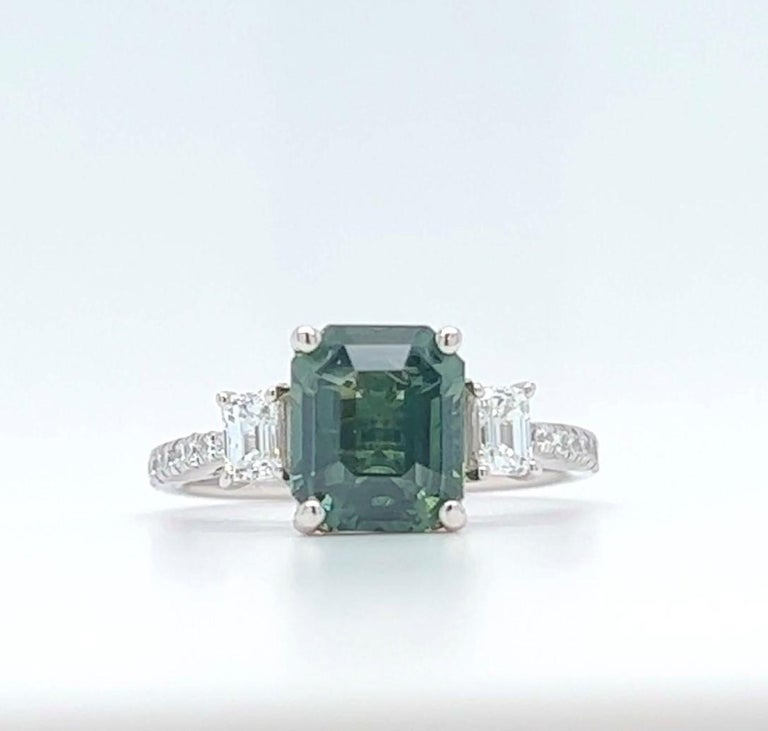 3.28ct Emerald Cut Green Sapphire Ring with Emerald Cut Diamond side stones (F/G VS) with a total diamond weight of 0.75ct set in a beautiful 18K White Gold setting. 