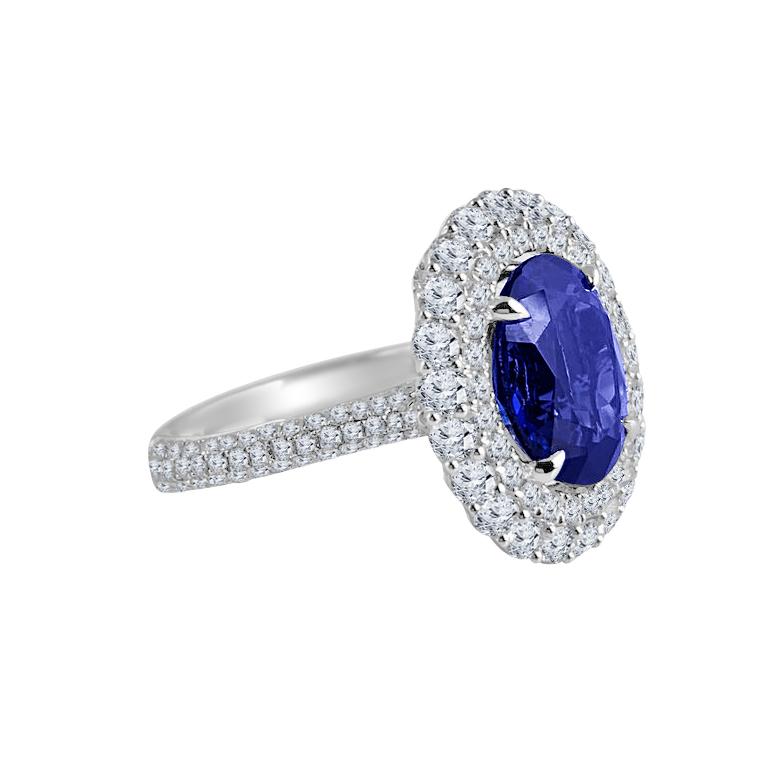 (DiamondTown) Dieser wunderschöne Ring enthält einen 4,64 Karat schweren Tansanit im Ovalschliff, der von einem doppelten Halo aus runden weißen Diamanten umgeben ist. Zusätzliche Diamanten entlang des Seitenschaftes sowie in der verzierten