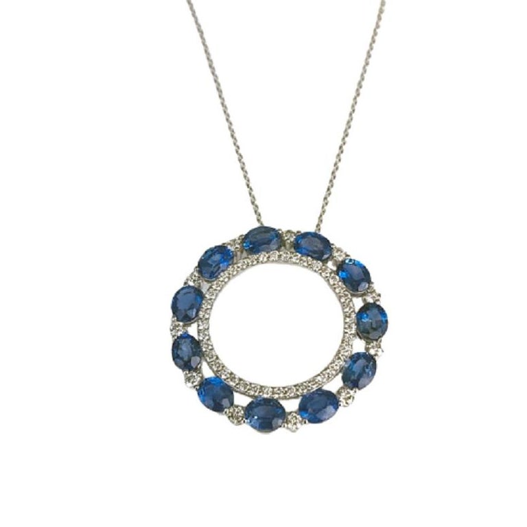 This beautiful pendant has a center halo of round white diamonds, surrounded by a halo of oval cut sapphires alternating with round white diamonds. The total sapphire weight is 4.69 carats. The total diamond weight is 0.76 carats.

Sapphires: 11