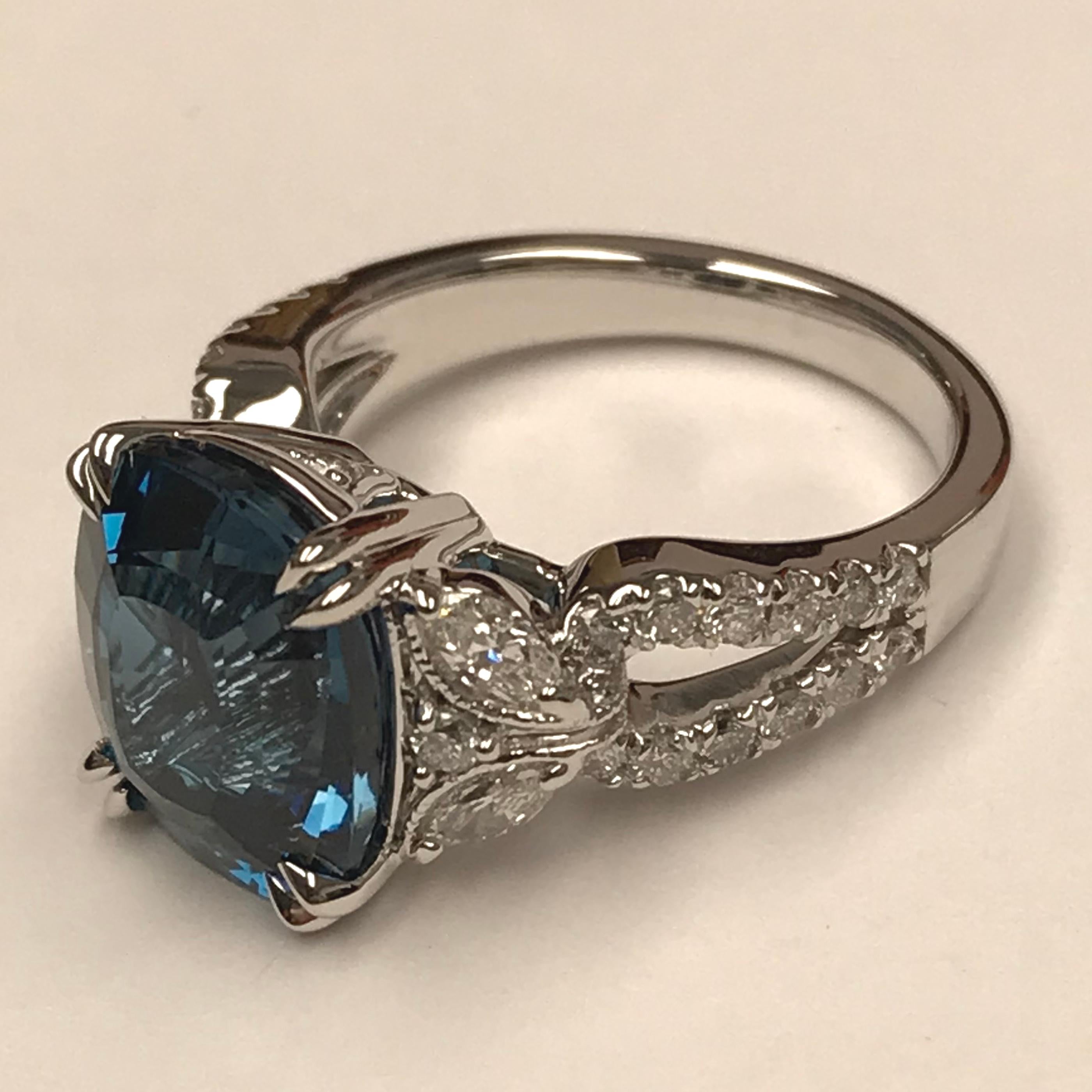 This gorgeous ring features a 12mm by 10mm Oval Cut London Blue Topaz center, atop a gorgeous hand engraved milgrain setting. The side shank features a delicate butterfly design, made of marquis and round cut white diamonds.

The total center weight