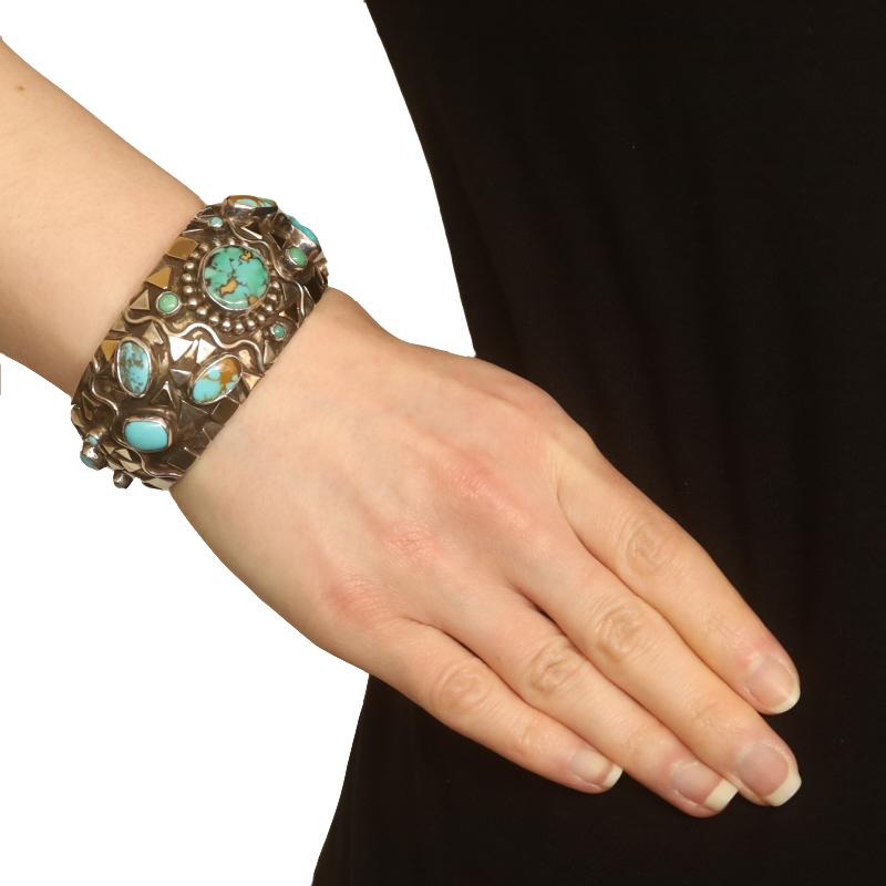 Designer: Dian Malouf

Metal Content: Sterling Silver & 14k Yellow Gold

Stone Information
Natural Turquoise
Treatment: Routinely Enhanced
Color: Blue, Bluish Green, Tan, & Brown

Style: Cuff
Fastening Type: N/A (slides over