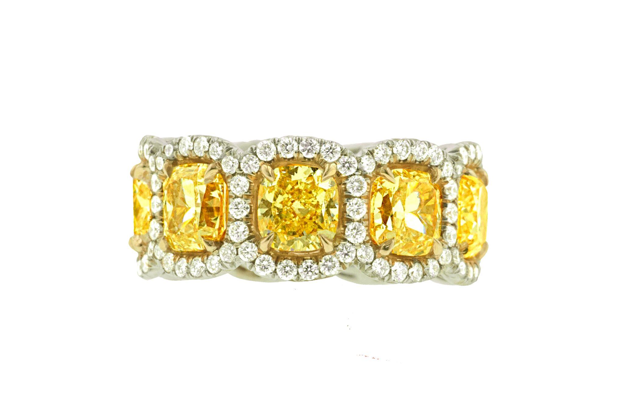 18kt white and yellow gold custom eternight band featuring 11.22 carats of fancy yellow cushion cut diamonds alongside 2.00 carats of round diamonds in a halo design 
