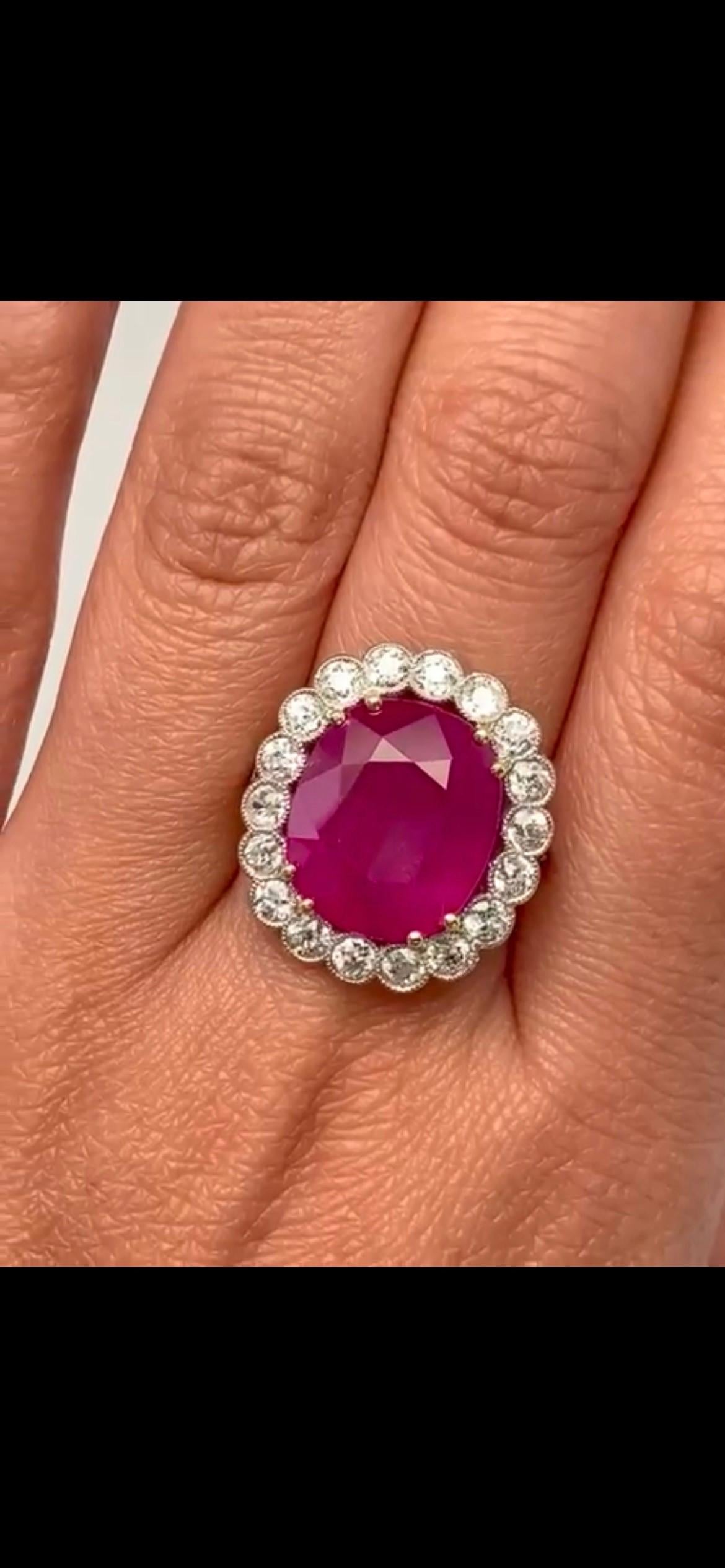 18 karat yellow gold, ring showcases a stunning 11.40 carat Burma ruby at its center, certified by GRS.  surrounded by this magnificent ruby are 1.00 carats of dazzling white diamonds, enhancing its beauty and brilliance.