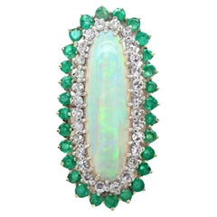 Diana M. 18 kt white gold opal, emerald, and diamond ring featuring a 7.00 ct 