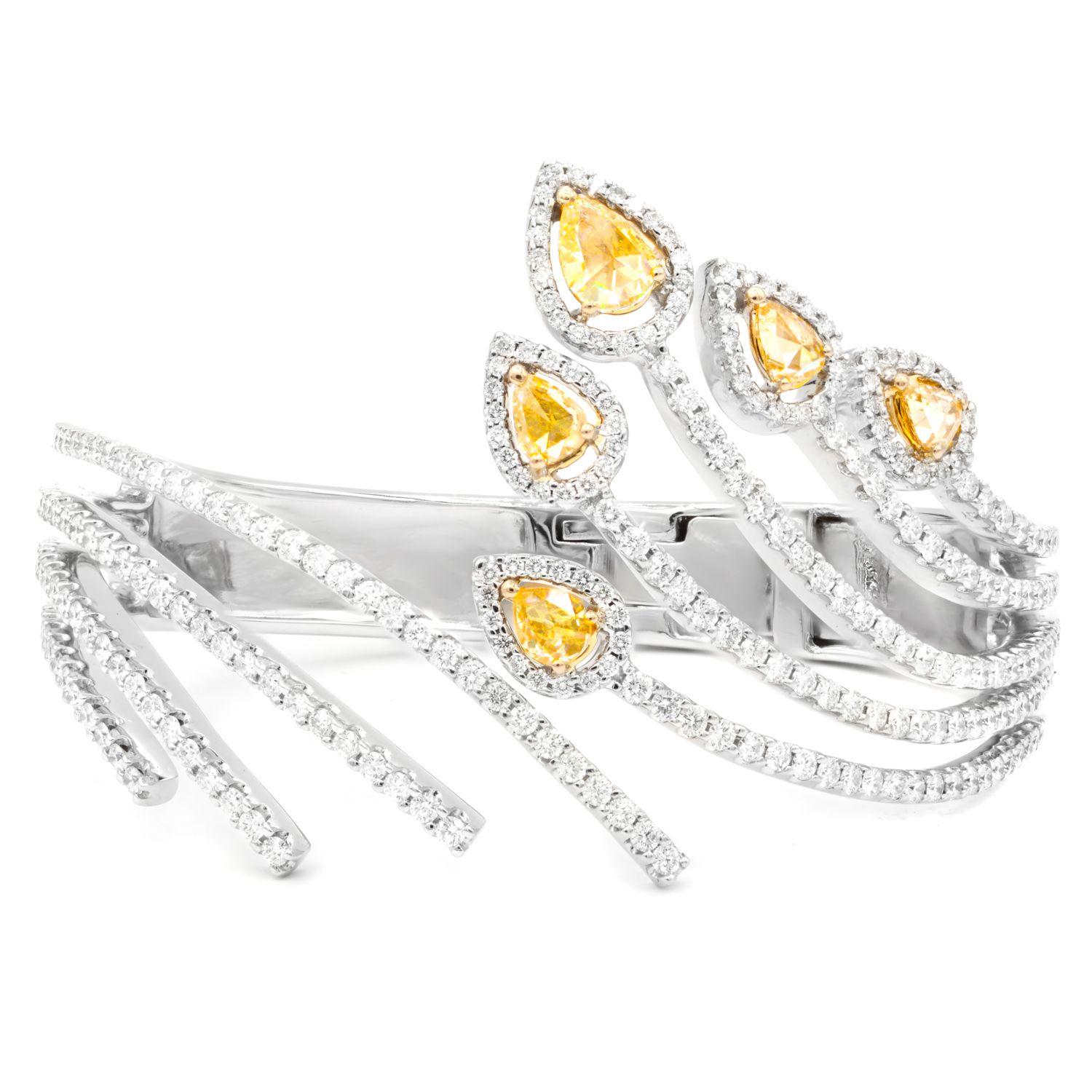 18 kt white gold diamond spiral bangle lined with white diamonds and yellow diamonds in a leaf design totaling 8.00 cts tw of diamonds