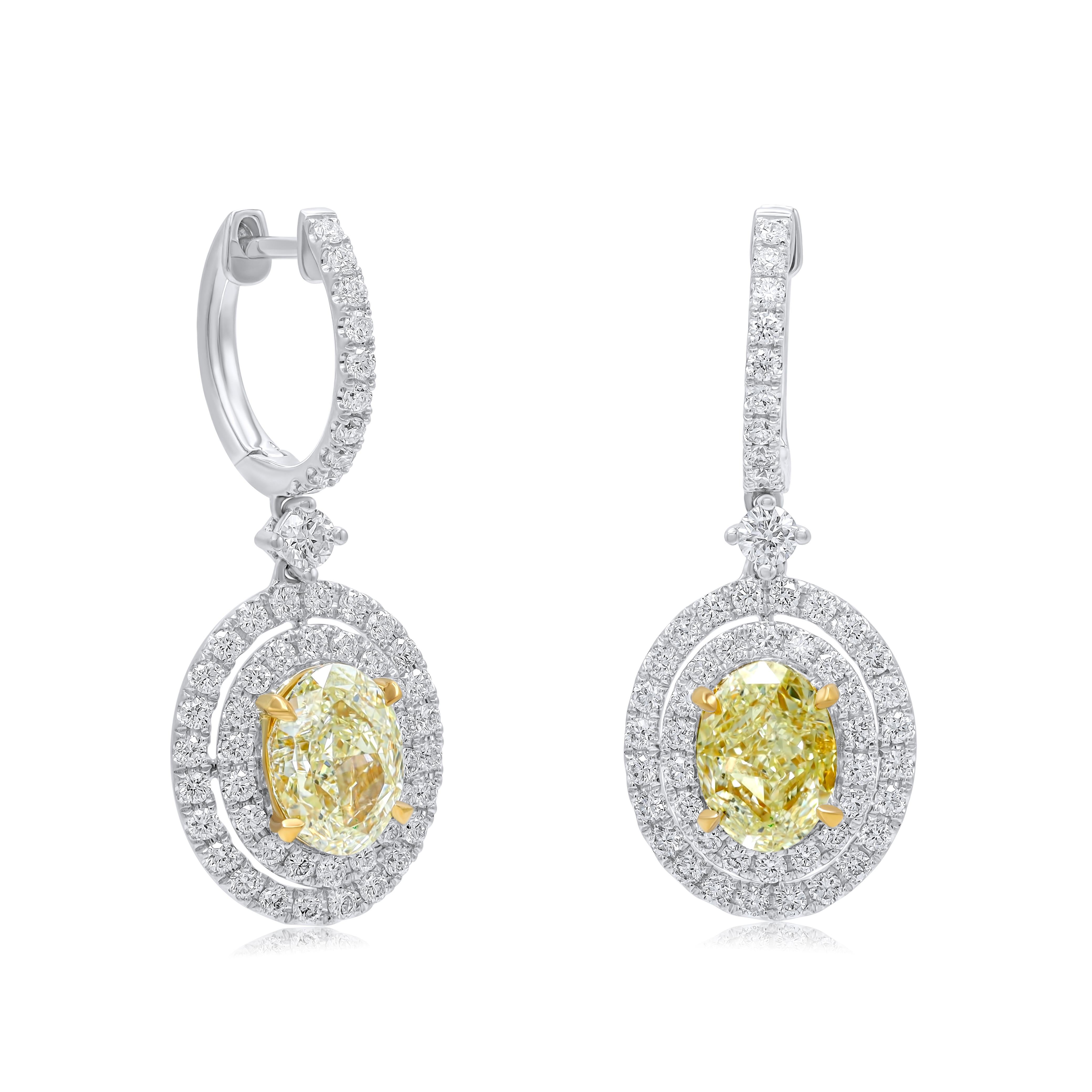 18kt Two Tone Fancy Light Yellow  Diamond Earrings.  These earrings feature 2 GIA certified Fancy light oval shape diamonds 3.00cts total weight  surrounded  with double halo and 1.25cts 