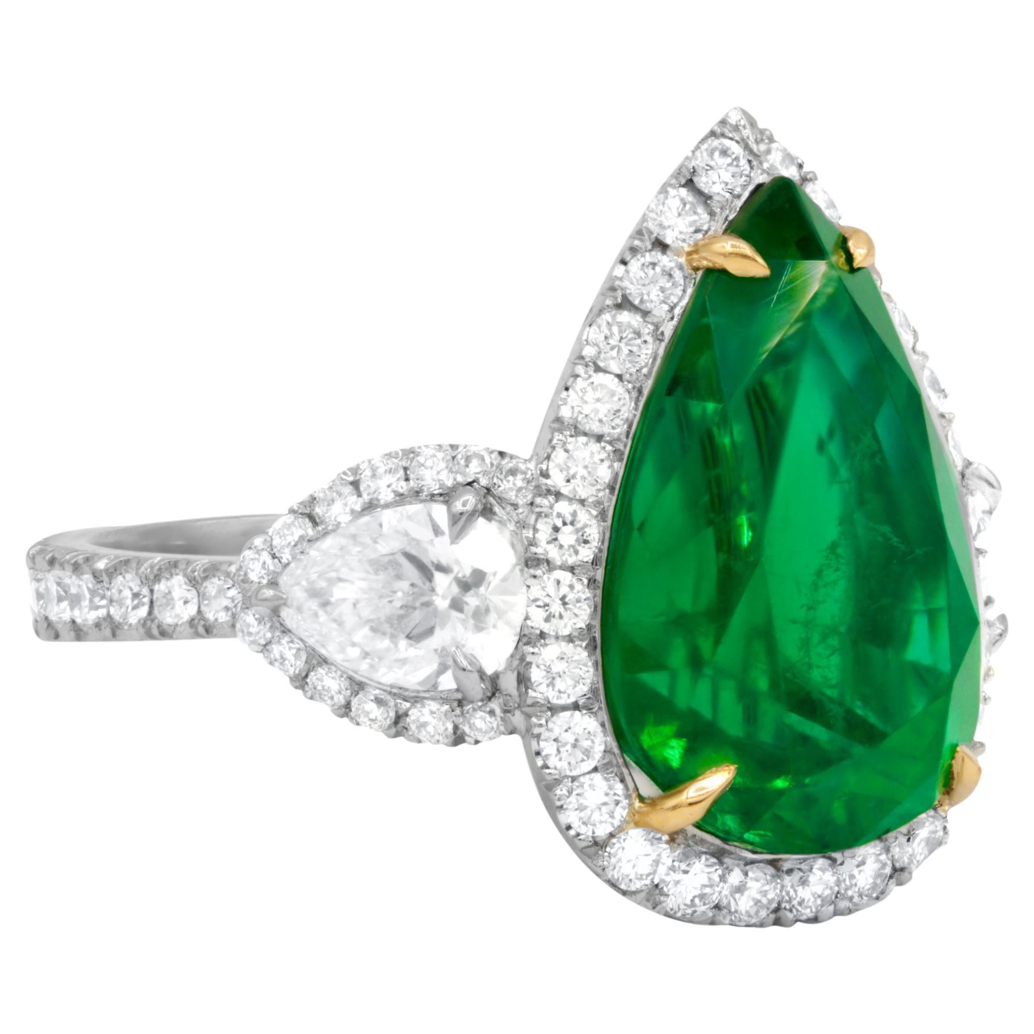 Cette magnifique bague personnalisée contient une émeraude en forme de poire certifiée GIA de 8,78 carats entourée de 2 diamants en forme de poire certifiés GIA de 1,02 cts. et d'un diamant en forme de poire certifié GIA de 1,02 cts.  Diamants ronds