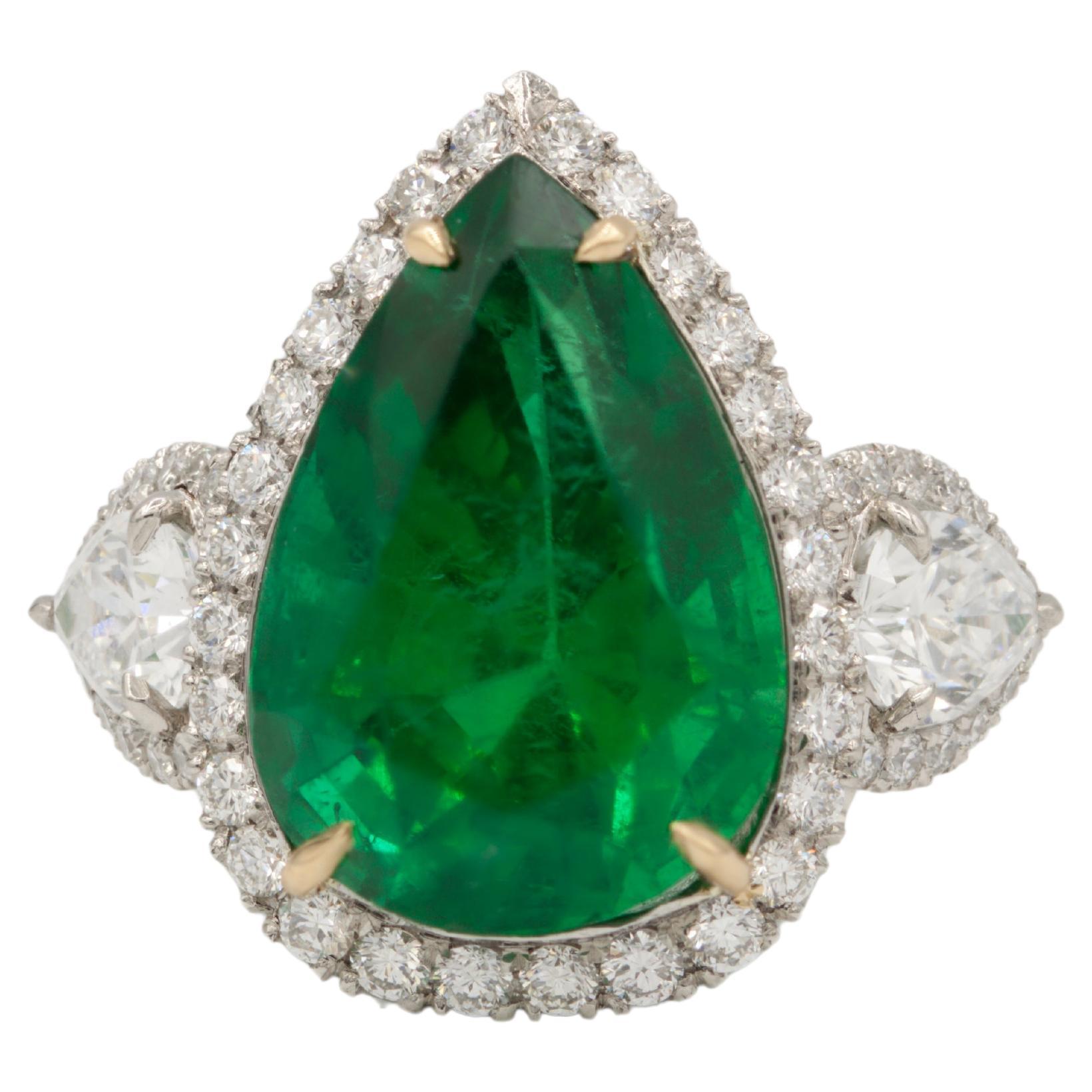 Exquisite in its design, this captivating ring boasts a stunning 8.78 ct pear-shaped green emerald, elegantly set in a luxurious combination of platinum and 18kt yellow gold. Flanking the emerald are two pear-shaped diamonds, each certified by GIA