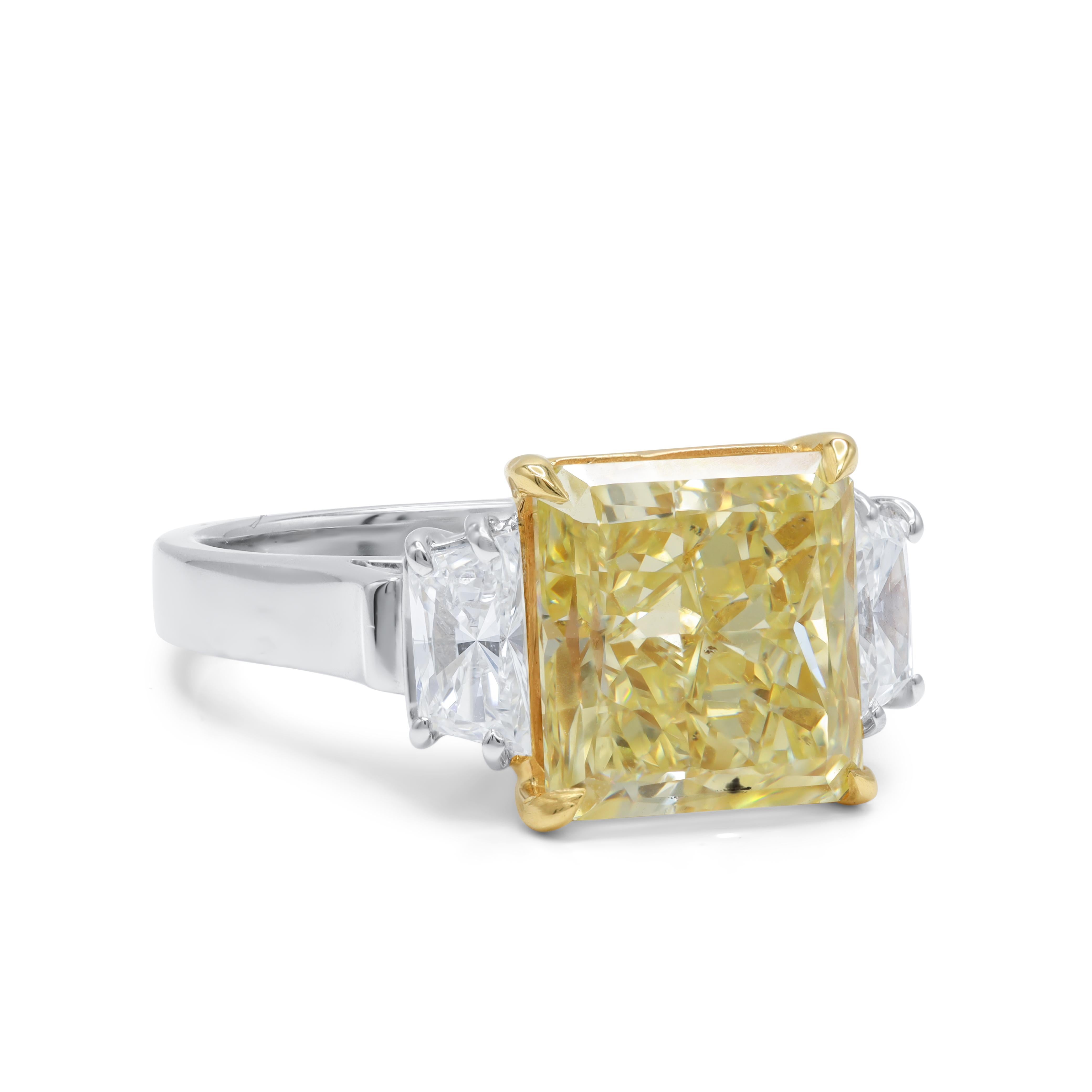  
Platinum and 18kt diamond engagement ring with center diamond 5.16ct Fancy Yellow SI1 GIA certifies 5.16cts with .90cts of trapezoids on the sides 
