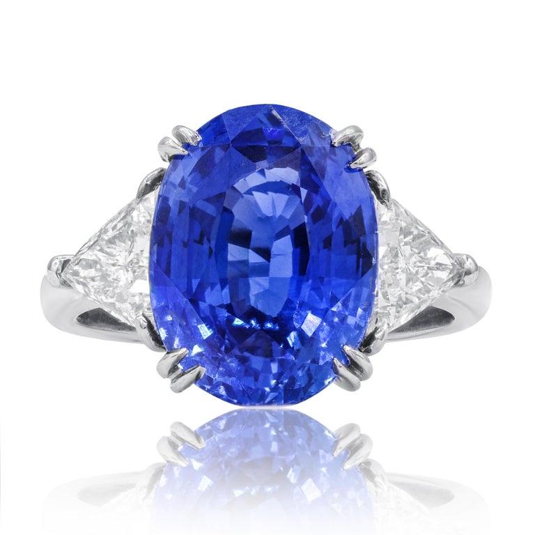 Platinum custom sapphire and diamond ring featuring an 8.51 ct oval certified Sri Lanka natural Ceylon blue sapphire with 2 triangle cut diamonds  F color VS clarity, sides totaling 1.27 cts of diamonds C. DUNAIGRE certified. Ecxellent cut. 


