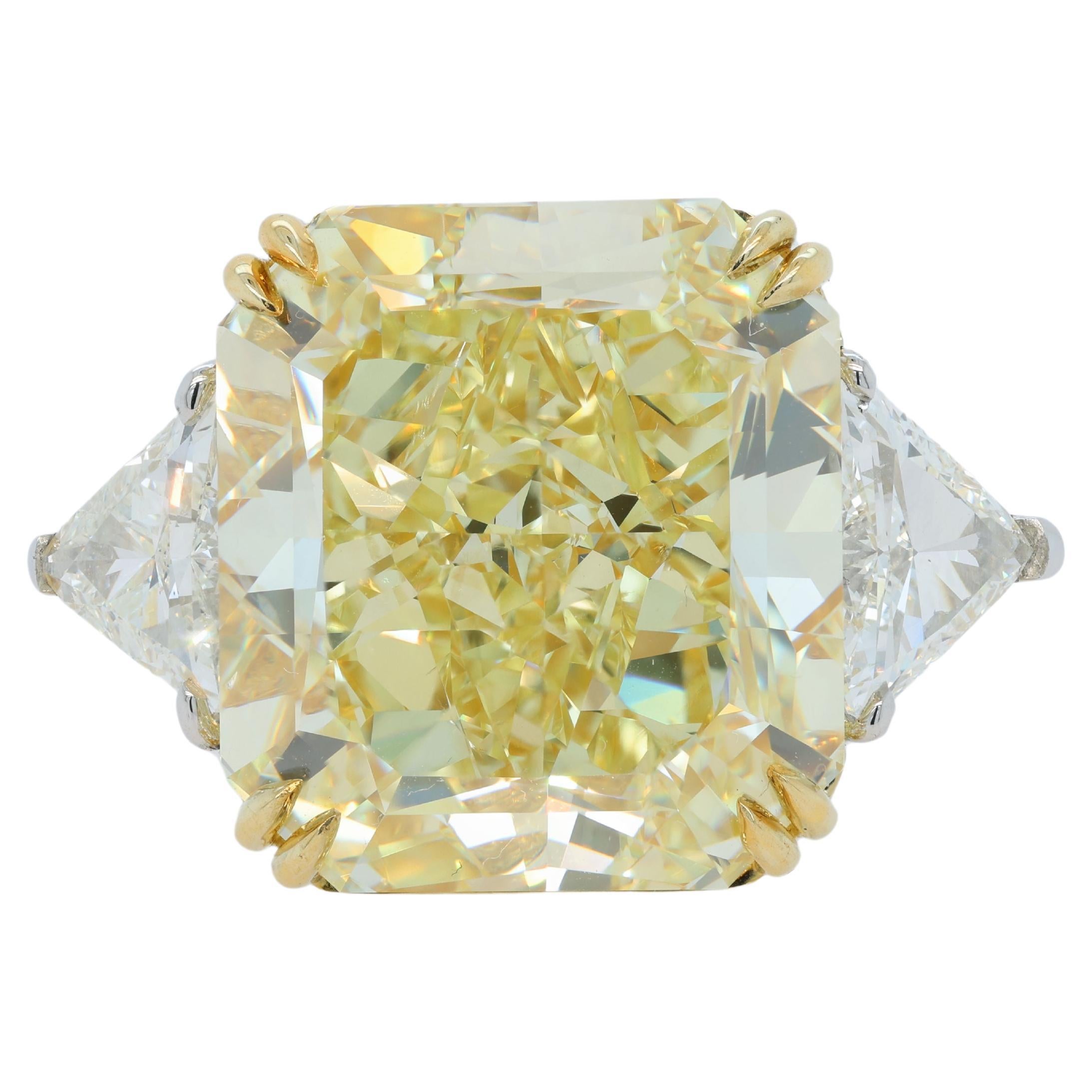 Platinum and 18 kt yellow gold engagement ring featuring a center (FIY VS2) 23.88 ct Radiant cut yellow diamond(GIA# 5161984914) with 1.56 cts tw of trilliant diamonds on the sides 
