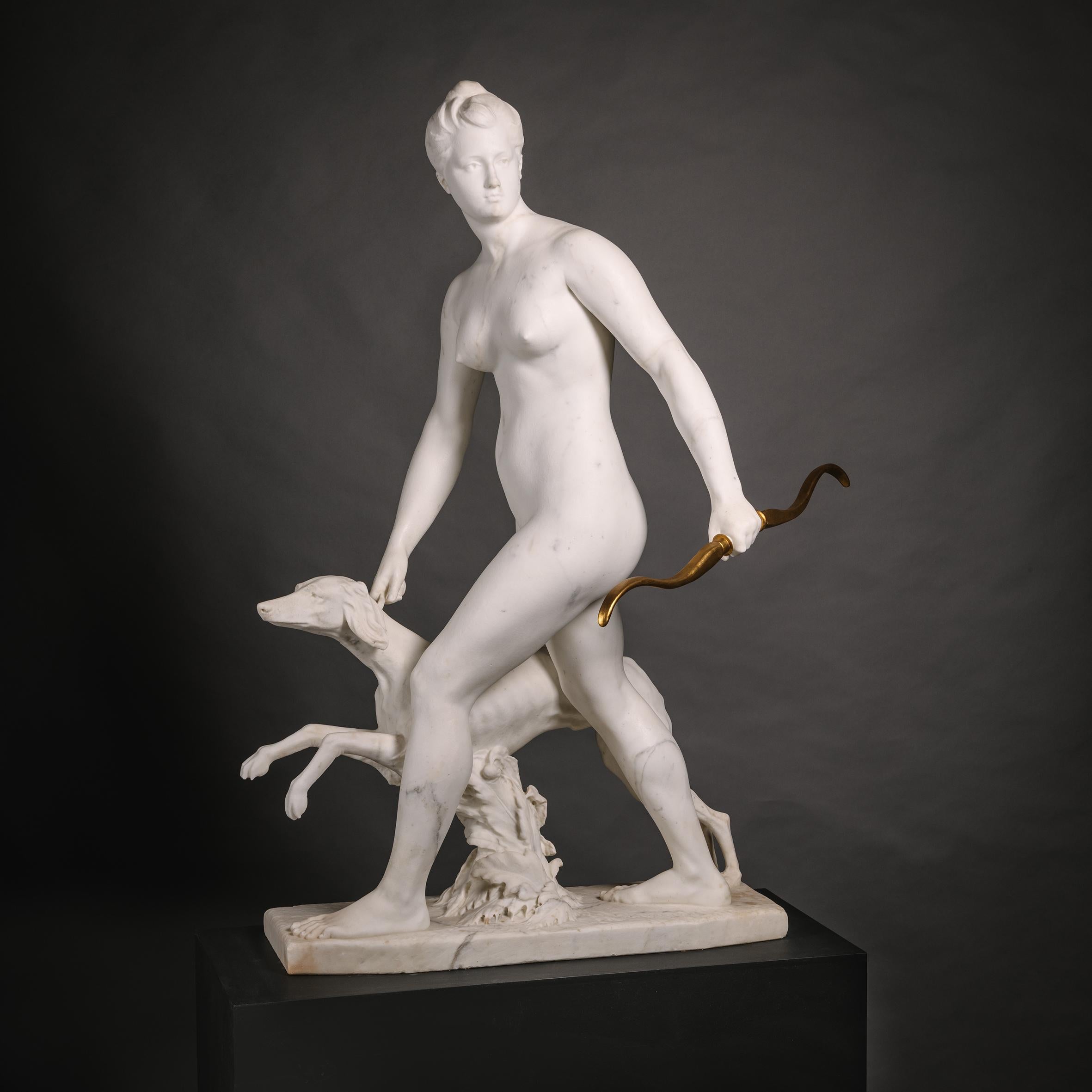 Alfred Boucher (French, 1850-1934), ‘Diana the Huntress’, A Near Lifesize Statuary Marble Group. 

Modelled nude with head turned looking to her left, striding forward holding the greyhound by its collar with her right hand and a giltwood bow in her