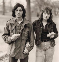 A young man and his girlfriend with hot dogs in the park
