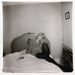 Girl in a coat lying on her bed, N.Y.C