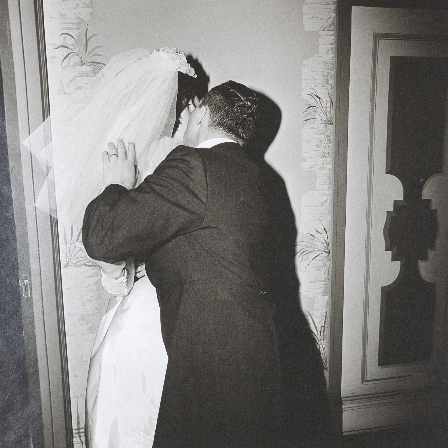 Bräutigam küsst seine Braut – Photograph von Diane Arbus