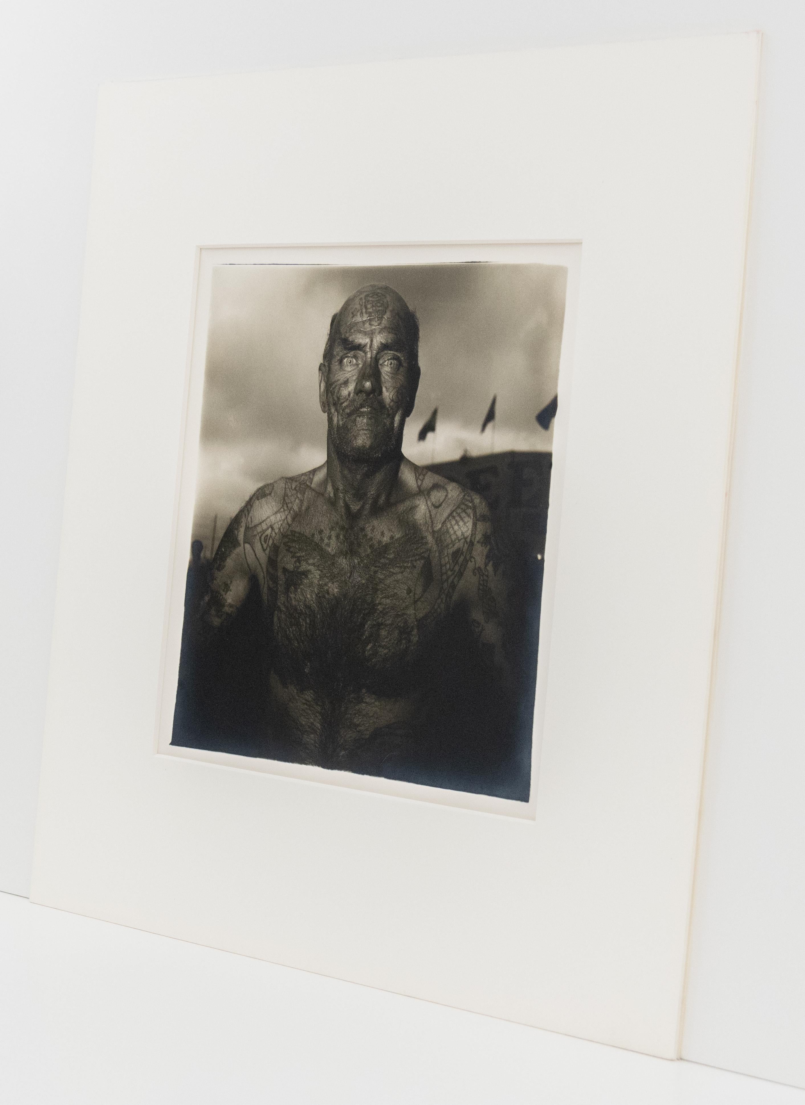 Uomo tatuato a Carnevale - Black and White Photograph Nero di Diane Arbus