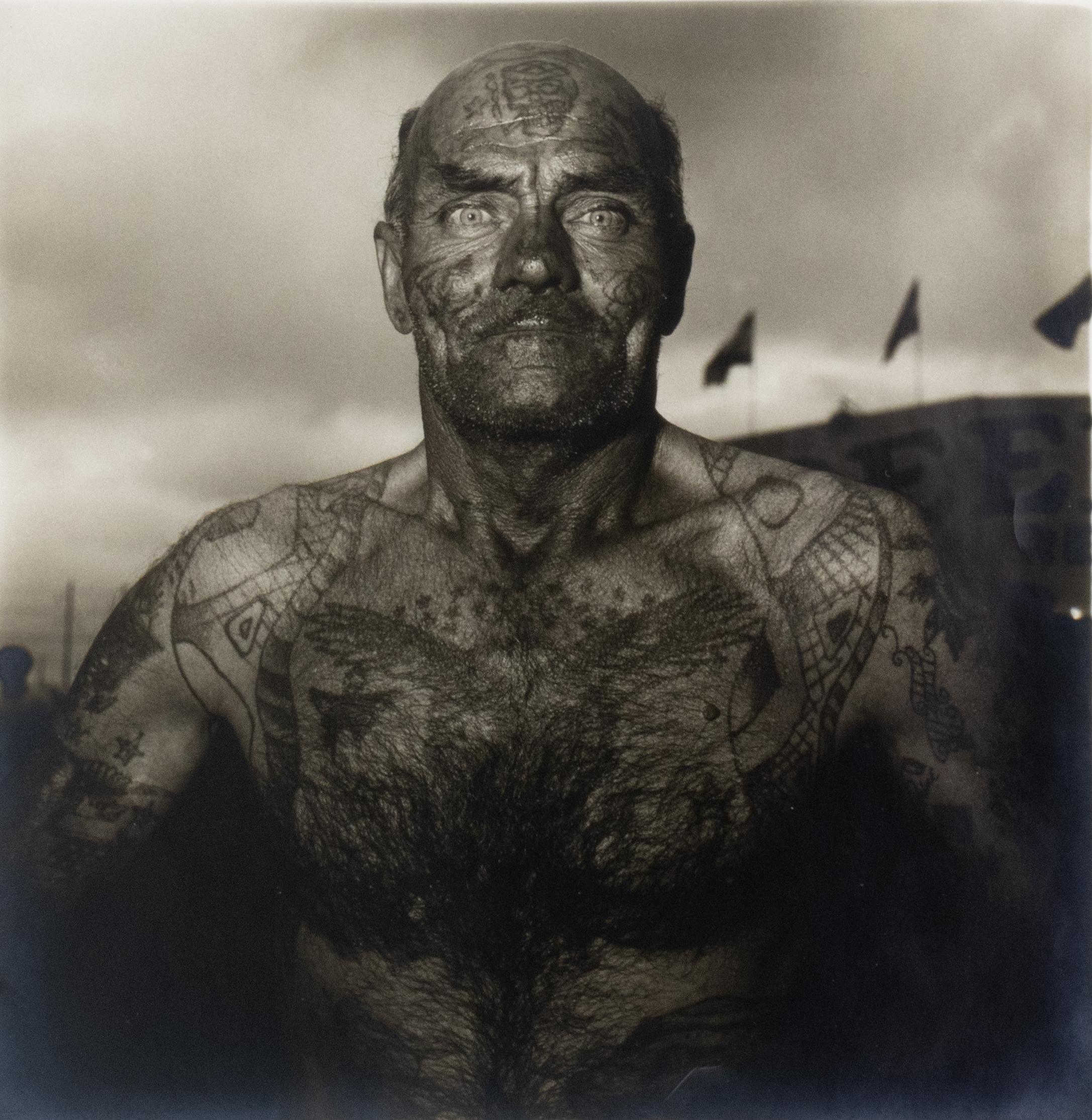Black and White Photograph di Diane Arbus - Uomo tatuato a Carnevale