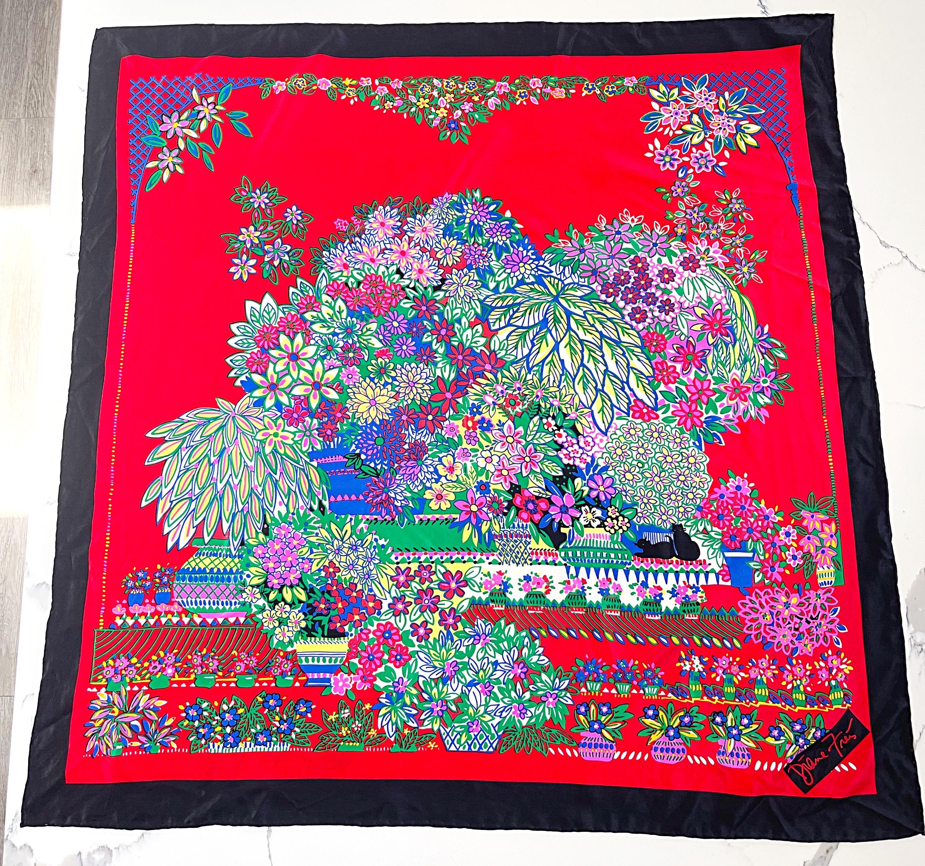 Colorful 1980s DIANE FREIS large silk scarf ! The options are endless with this beauty. Wear it as a headscarf, drape it around your shoulders as a shawl, wear it wrapped around your neck, etc. 
Red backdrop with black border. Colorful flowers in