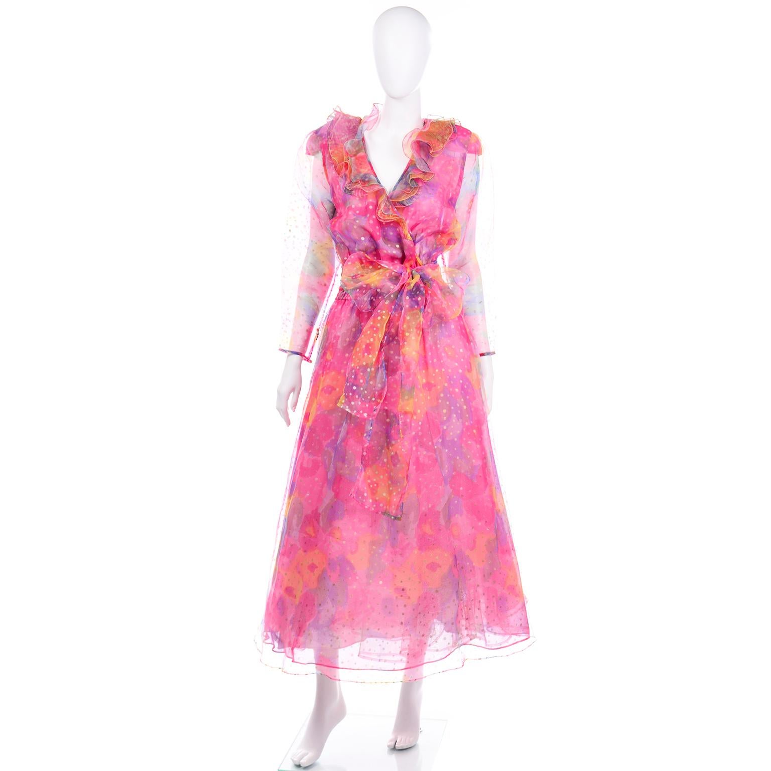 This vintage Diane Freis dress is absolutely stunning! The fabric is a beautiful pink, yellow and purple watercolor design with gold metallic polka dots. The top of the dress is a faux wrap style and we love the dramatic ruffled collar. The