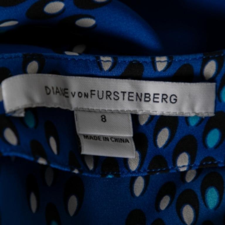Dieses Maggy-Top von Diane von Furstenberg ist schlicht und doch stilvoll. Es ist aus Seide geschneidert, hat einen Chevron-Punktedruck auf blauem Grund, kurze Ärmel und einen Knopfverschluss am Rücken. Tragen Sie es zu einer schwarzen oder weißen