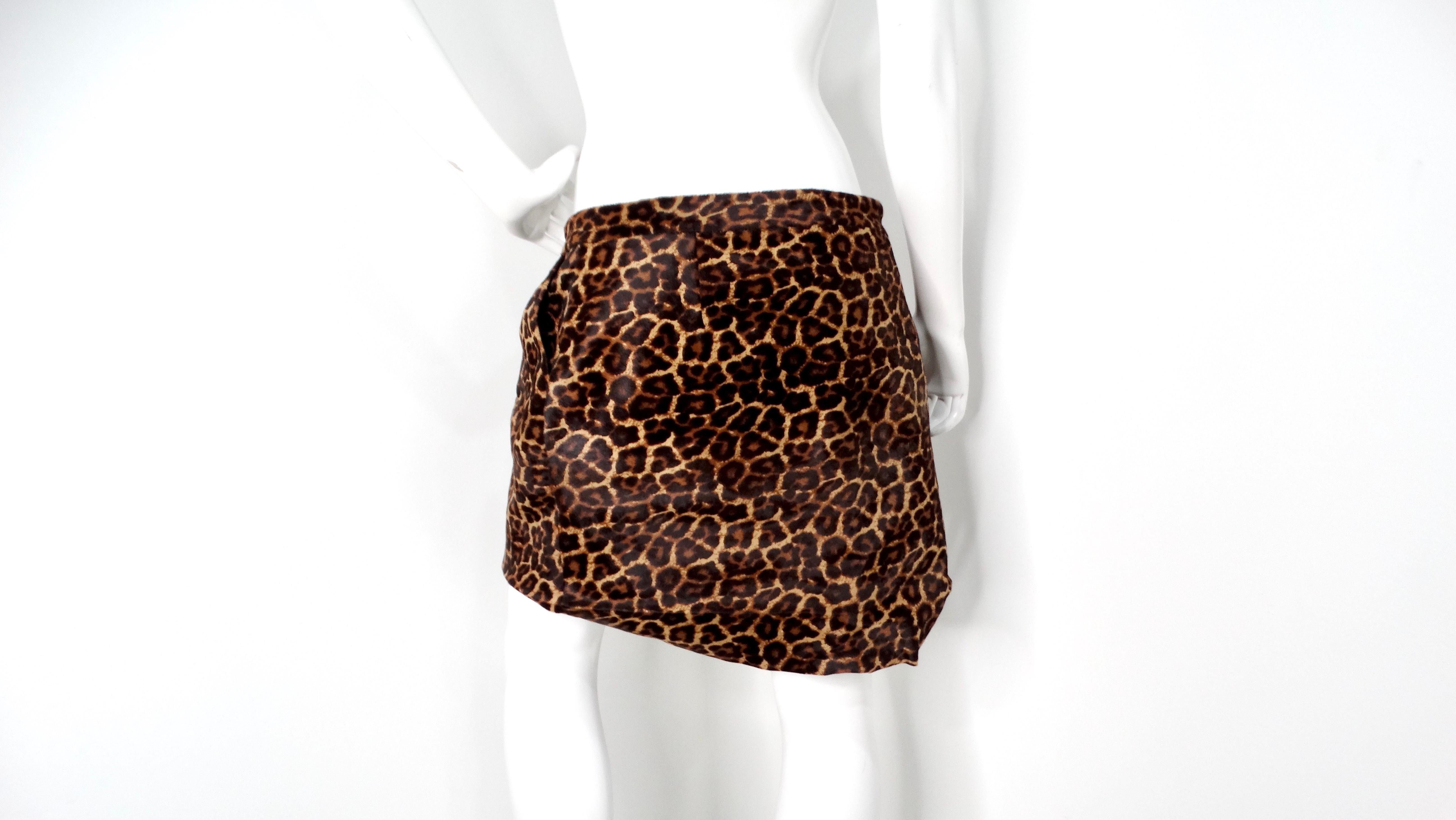 The Diane Von Furstenberg Leopard Print Calf Hair Mini Skirt is a stunning piece that stylishly fuses bold animal print with sophisticated design. This mini skirt wraps elegantly around the waist, secured with two chic buttons, offering a flattering