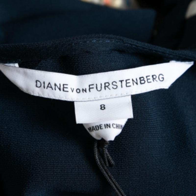 Diane von Furstenberg weiß am besten, wie Sie mit diesem Oberteil umwerfend aussehen können. Es ist aus marineblauem Seidenstoff gefertigt, der mit Kristallverzierungen hervorgehoben wird. Es hat kurze Ärmel und wird mit einem Reißverschluss