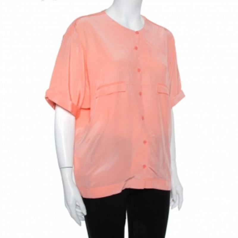 This top by Diane von Furstenberg skillfully merges front buttons, short sleeves, and a layered detail at the back with a casual, oversized silhouette. The pink women's top has a comfortable fit and a design that will look great with both pants and