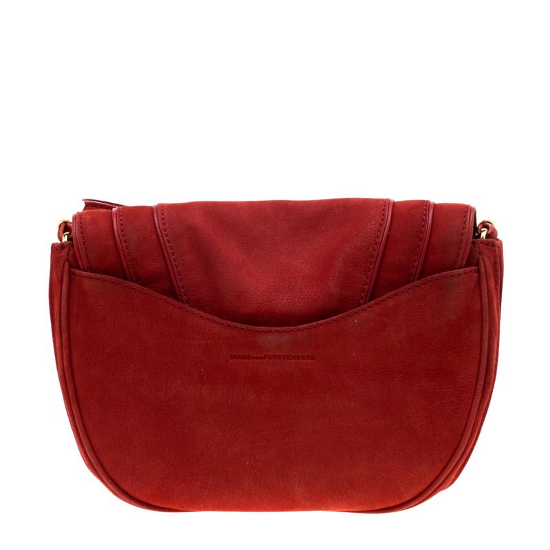This chic Bullseye crossbody bag from Diane Von Furstenberg is worthy of being yours. Crafted from red nubuck leather, the bag comes with a layered front flap and a back slip pocket. The flap opens to a satin-lined interior. Carry this stunning bag