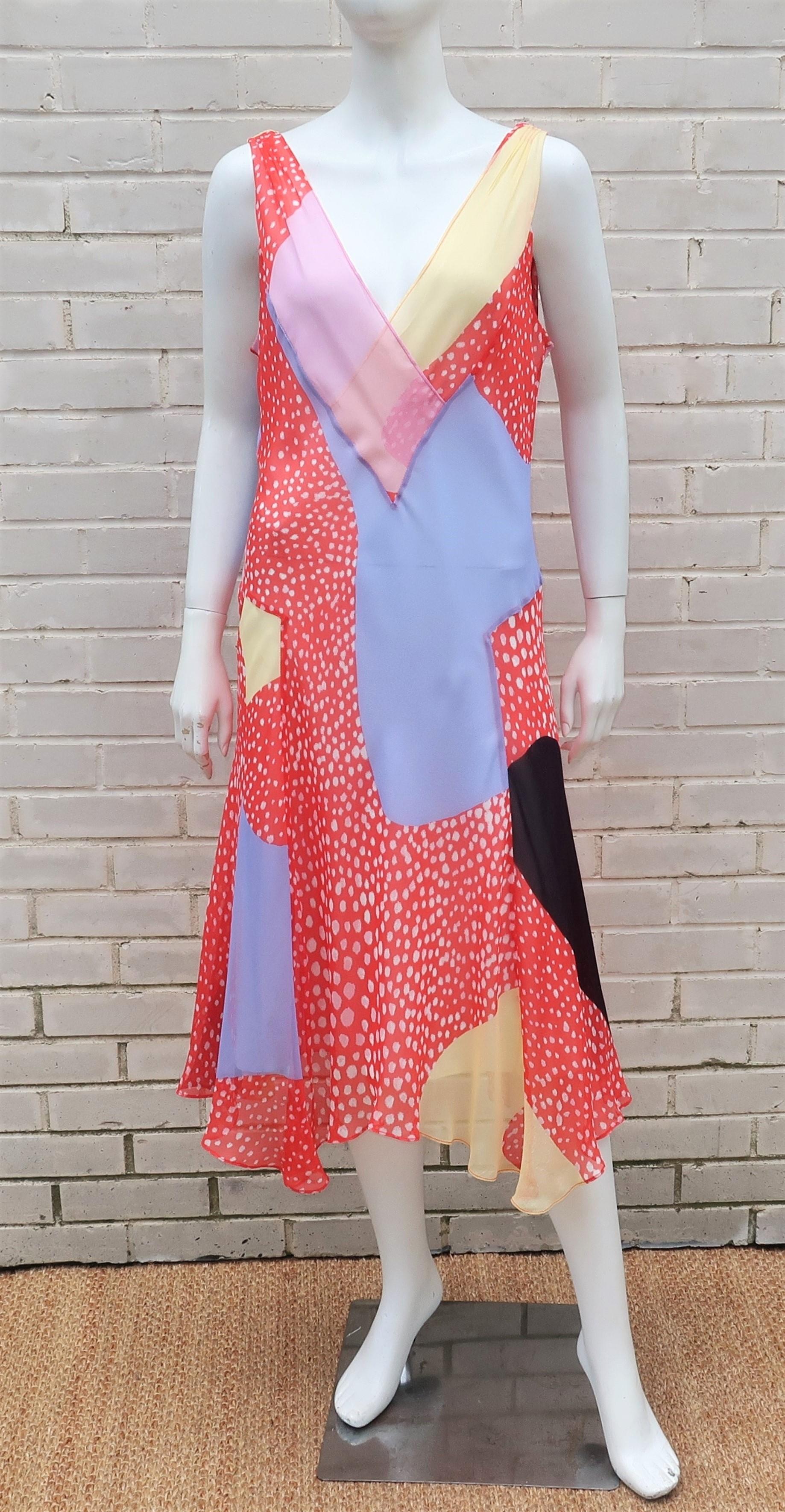 Diane Von Furstenberg’s stylish take on a handkerchief dress in a colorful patchwork of silk chiffon fabrics displaying red and white abstract polka dots accented with shades of pink, yellow, periwinkle blue and black.  The pullover construction