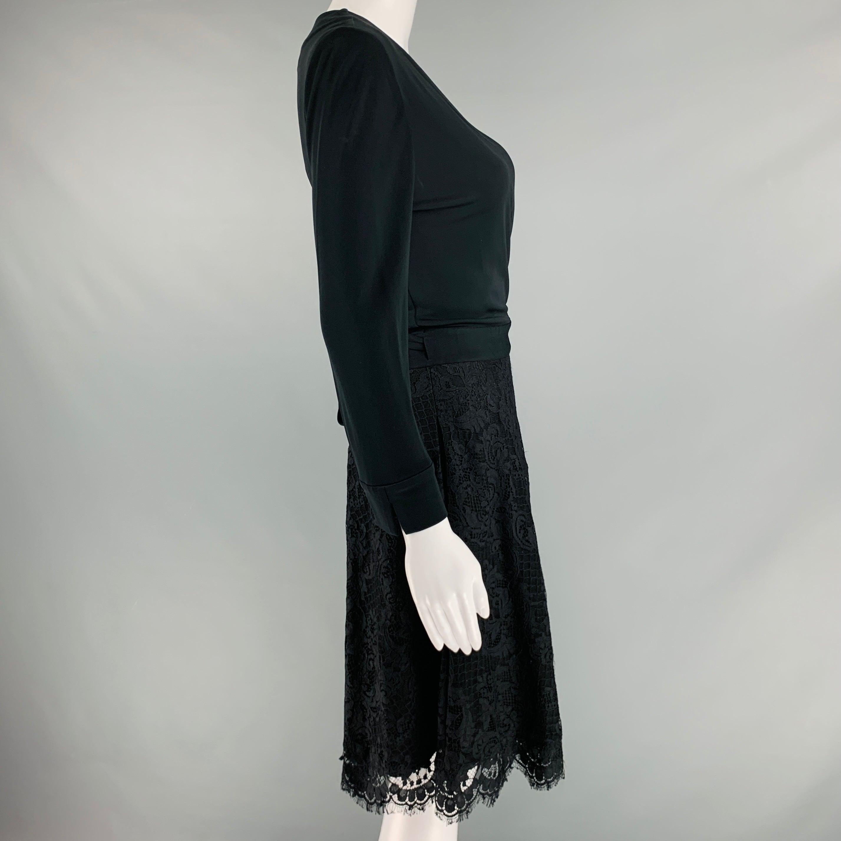 DIANE VON FURSTENBERG dress
in a black nylon fabric featuring a lace skirt, long sleeves, V-neck, and wrap style tie closure.Very Good Pre-Owned Condition. Signs of wear on lace. 

Marked:   4 

Measurements: 
 
Shoulder: 15 inches Sleeve: 21 inches