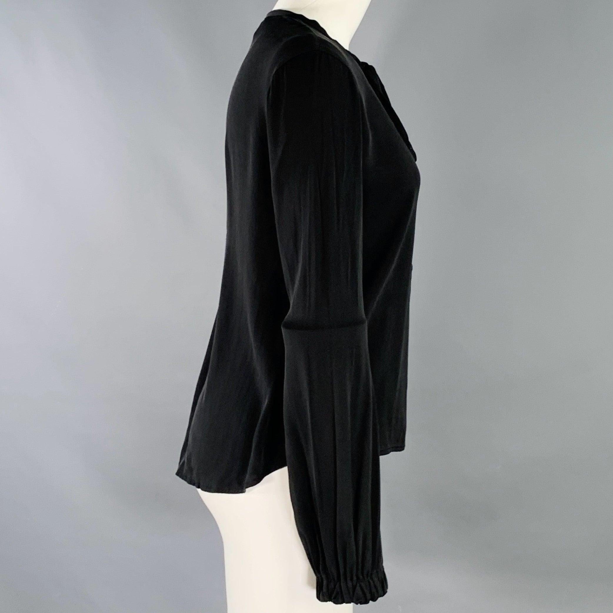 DIANE VON FURSTENBERG shirt
in a black silk stretch blend featuring blouson sleeves, and half placket closure with tie.Very Good Pre-Owned Condition. Minor marks. 

Marked:   6 

Measurements: 
 
Shoulder: 14.5 inches Bust: 37 inches Sleeve: 25