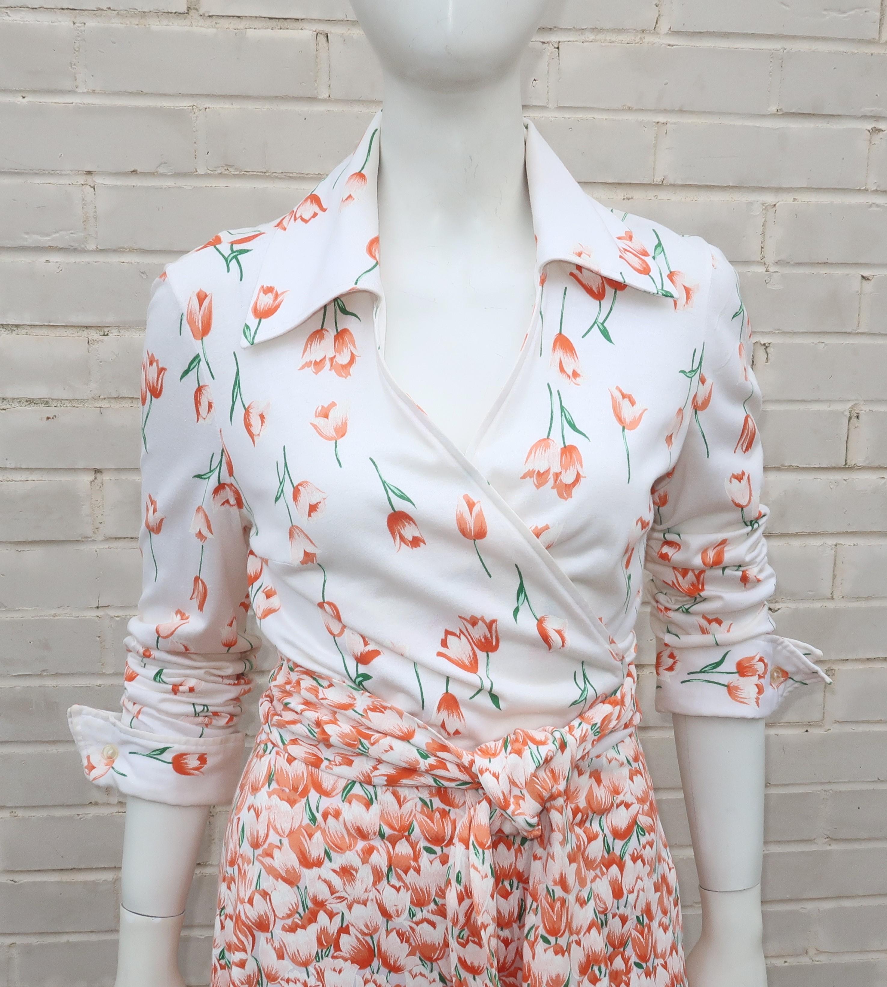 A classic 1970's Diane Von Furstenberg’s wrap dress in a cotton blend natural white knit fabric with an orange and green tulip print design.  The stylish wrap silhouette provides for a sexy plunging neckline framed by a pointy collar, finished