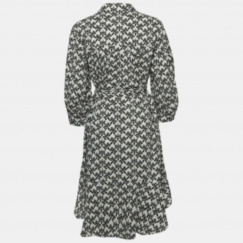 Immergiti nel fascino senza tempo dell'abito di Diane von Furstenberg. Realizzato con delicati motivi floreali su cotone bianco, questo abito emana una grazia senza sforzo. La sua silhouette sartoriale, completata da una cintura in vita, promette un